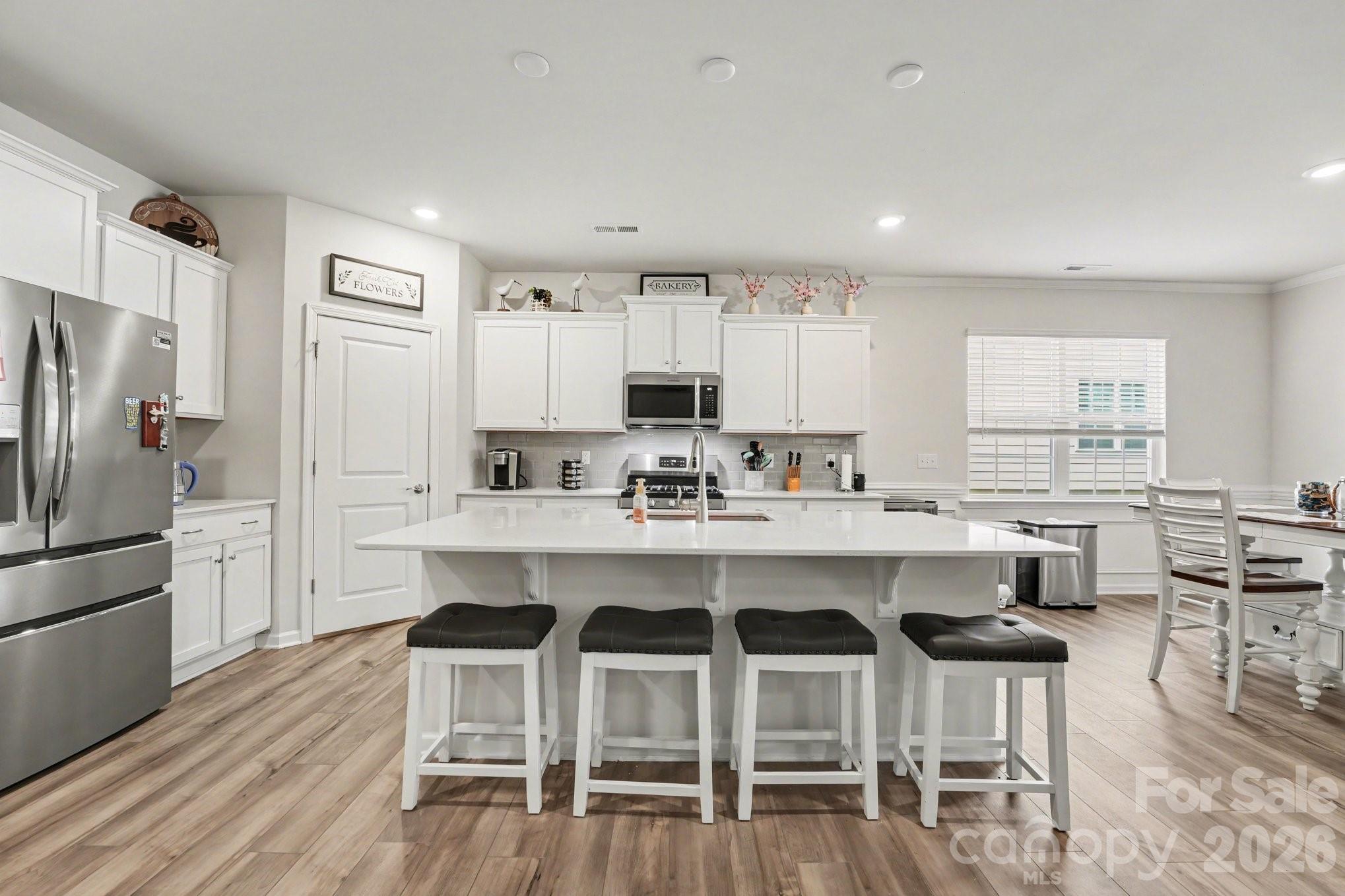 2971 Findley Road Statesville, NC 28625 - Photo 11 of 19 a kitchen with stainless steel appliances a dining table chairs refrigerator sink and cabinets