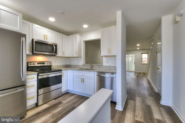 a kitchen with granite countertop stainless steel appliances and wooden cabinets