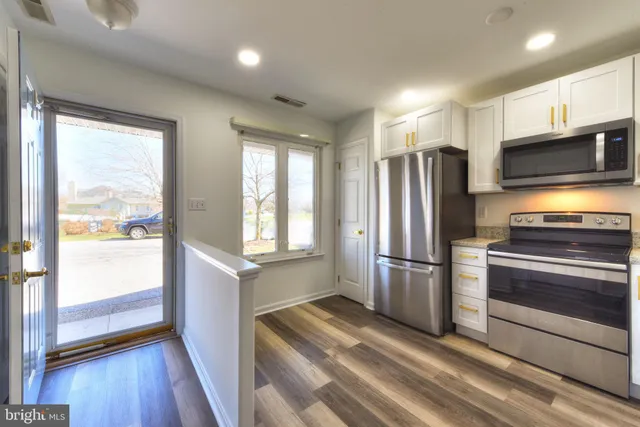 a kitchen with stainless steel appliances a refrigerator and a stove top oven