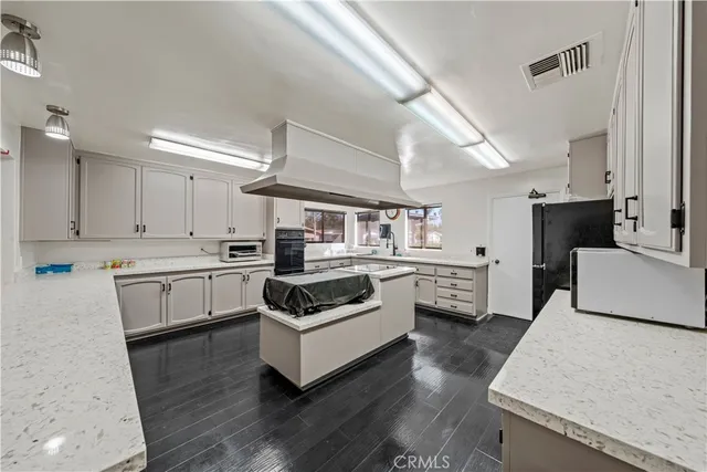 a kitchen with granite countertop white cabinets and white appliances