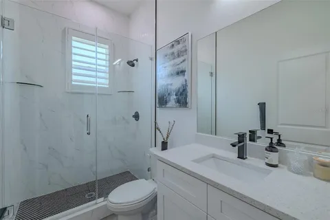 a bathroom with a toilet sink a mirror and shower