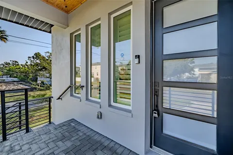 a kitchen with kitchen island granite countertop a sink a stove a oven a dining table and chairs with white cabinets