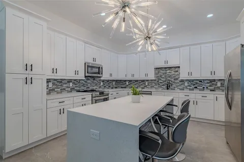 a kitchen with kitchen island granite countertop a sink a counter top space stainless steel appliances and cabinets