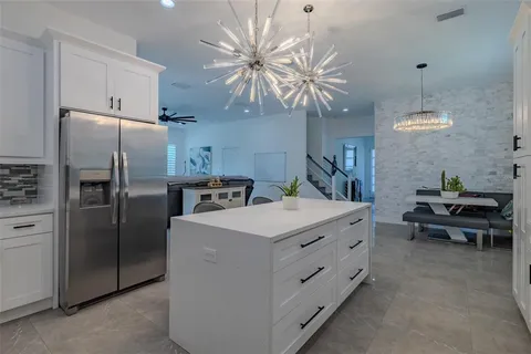a kitchen with white cabinets granite counter tops and a stove
