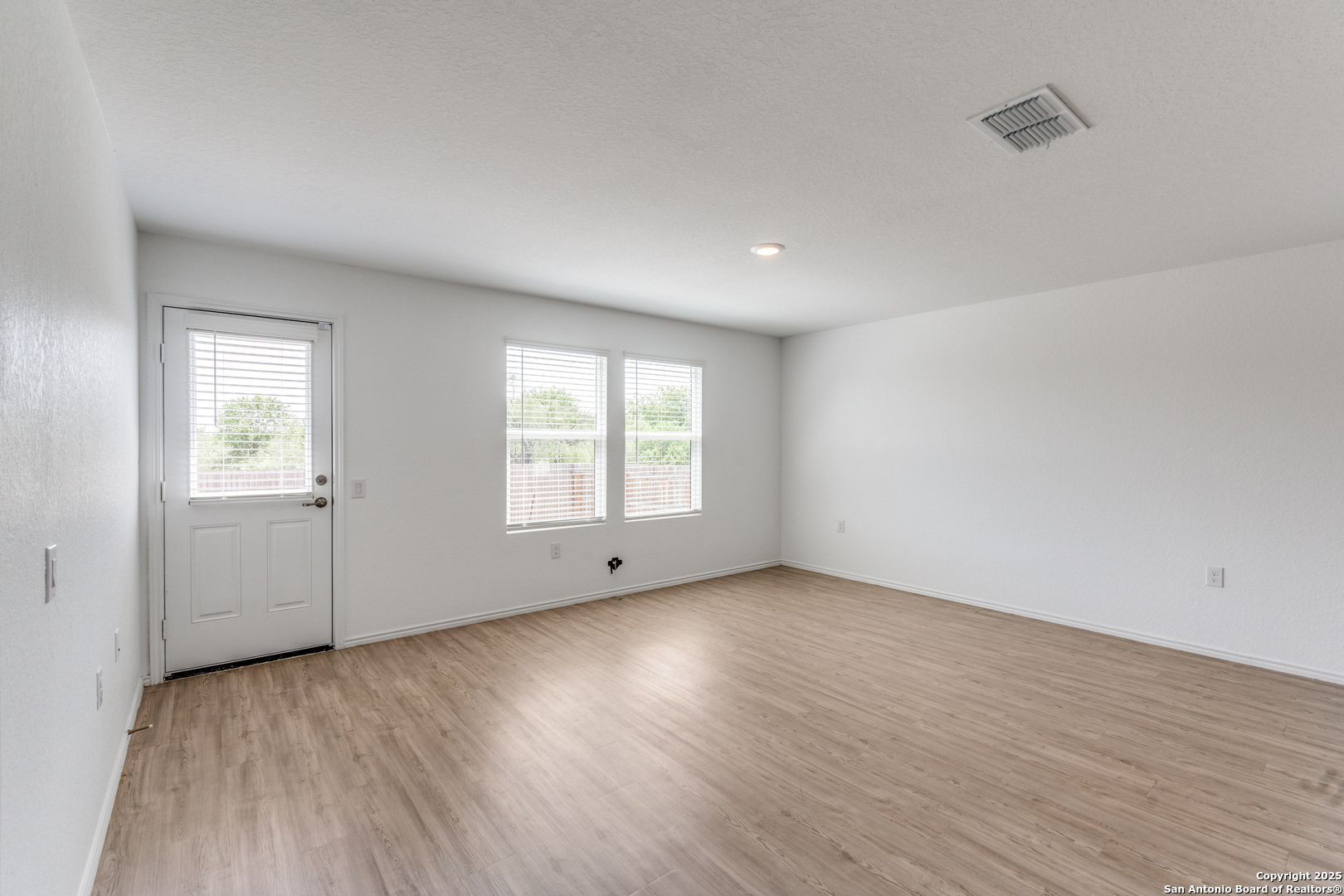 13503 Turnesa Terrace San Antonio, TX 78221 - Photo 11 of 25 an empty room with wooden floor and windows