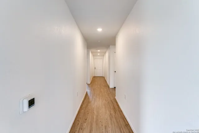 a view of a hallway with wooden floor