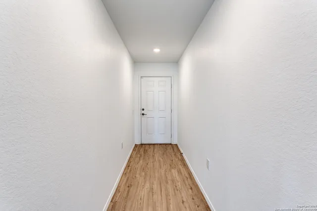 a view of a hallway with wooden floor