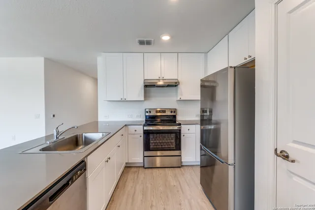 a kitchen with stainless steel appliances a refrigerator sink and cabinets