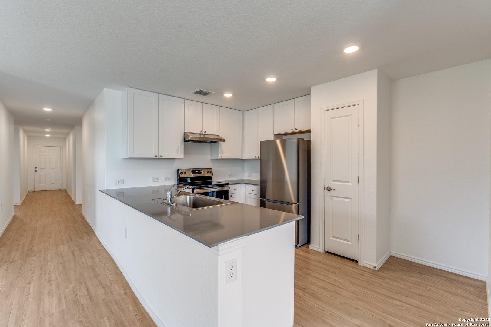 13503 Turnesa Terrace San Antonio, TX 78221 - Photo 4 of 25 a kitchen with stainless steel appliances granite countertop a refrigerator sink and cabinets