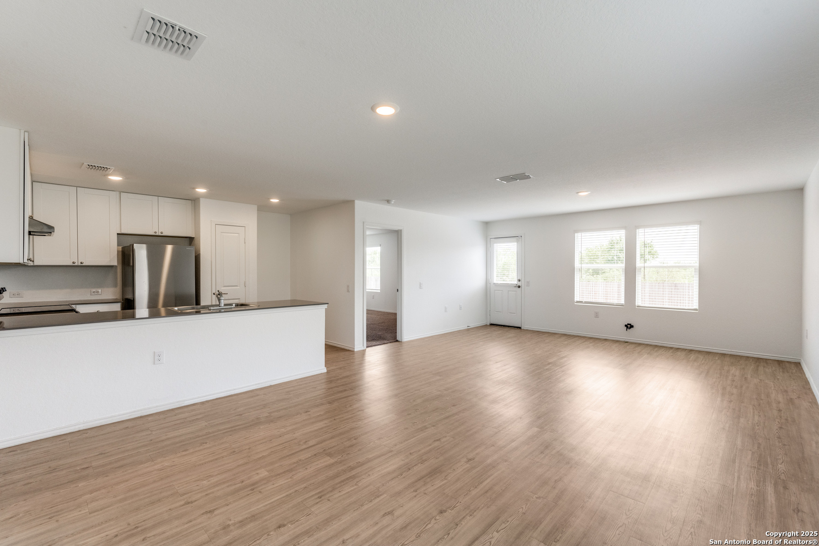 13503 Turnesa Terrace San Antonio, TX 78221 - Photo 6 of 25 a view of an empty room with wooden floor and a window