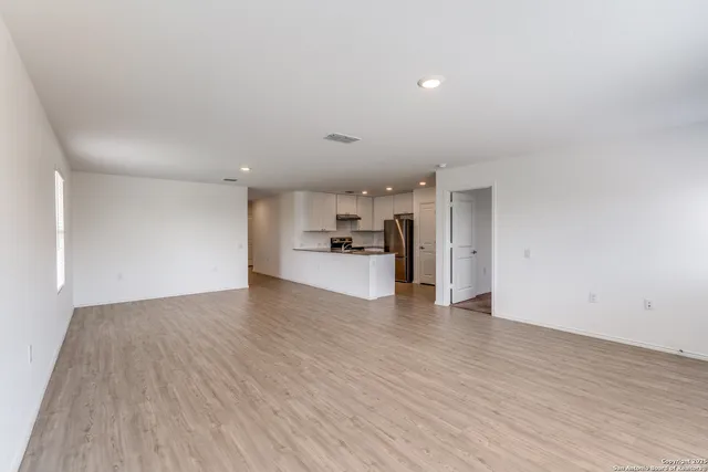 a view of large empty room with wooden floor