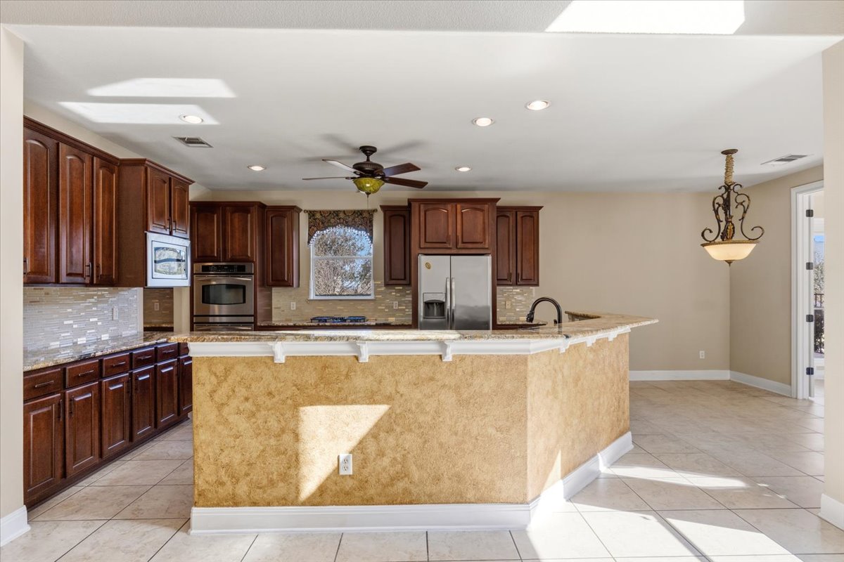 111 Whitley Drive Austin, TX 78738 - Photo 12 of 38 Kitchen with a wrap-around kitchen bar, granite counters, and stainless steel appliances.