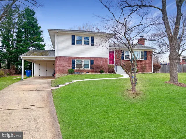 a front view of a house with a yard and trees