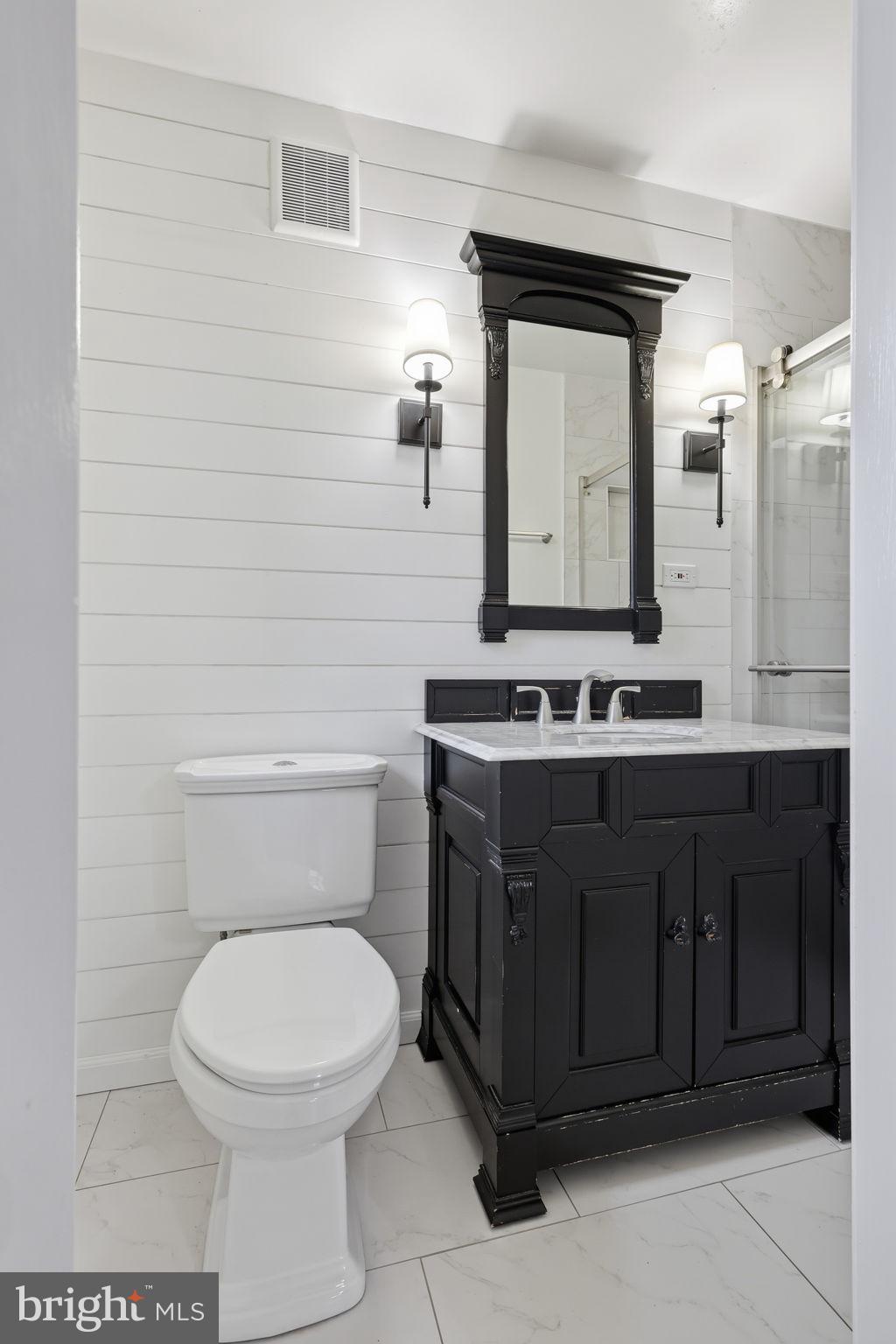 7114 Xavier Court McLean, VA 22101 - Photo 11 of 22 a bathroom with a toilet sink vanity and mirror