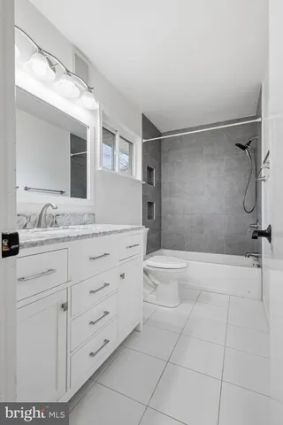 a bathroom with a granite countertop sink a toilet and shower