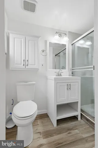 a bathroom with a toilet a sink and mirror