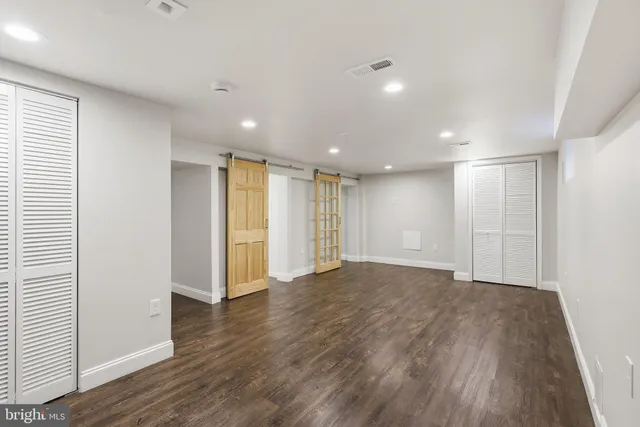 a view of empty room with wooden floor