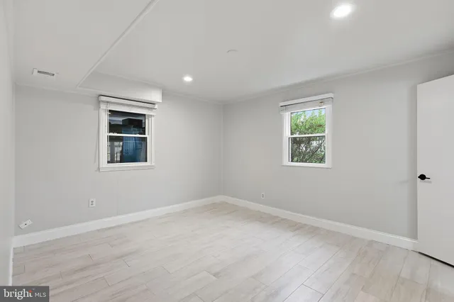 a view of a room with wooden floor and windows