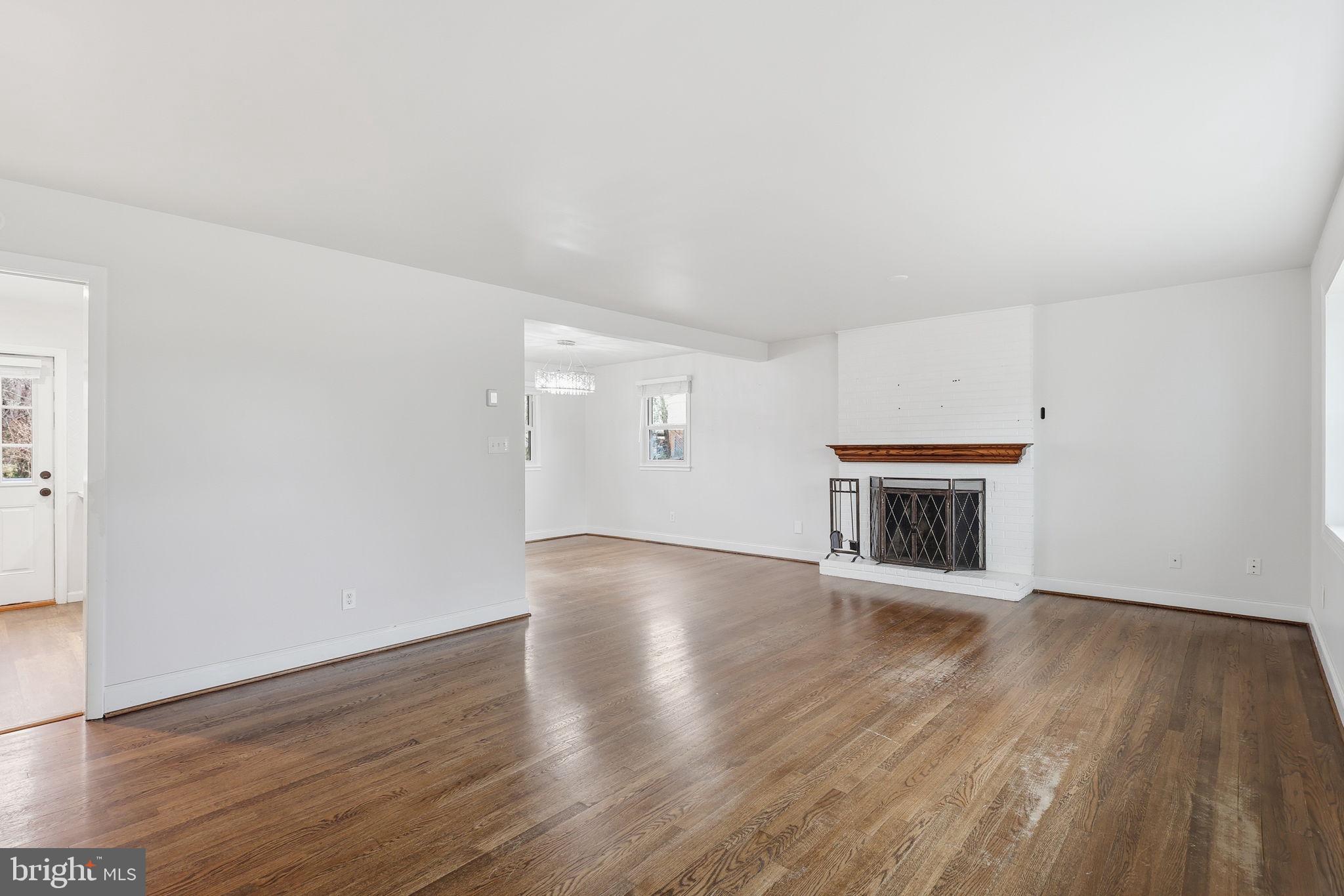 7114 Xavier Court McLean, VA 22101 - Photo 5 of 22 an empty room with wooden floor fireplace and windows