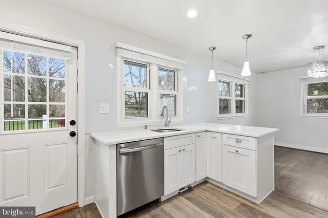 a kitchen that has a sink a window and cabinets
