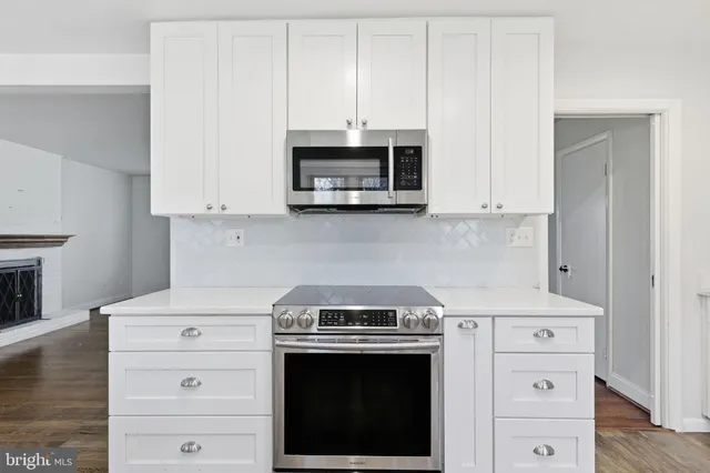 a kitchen with stainless steel appliances granite countertop a stove and a microwave