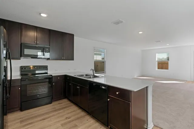 a kitchen with a sink appliances and cabinets