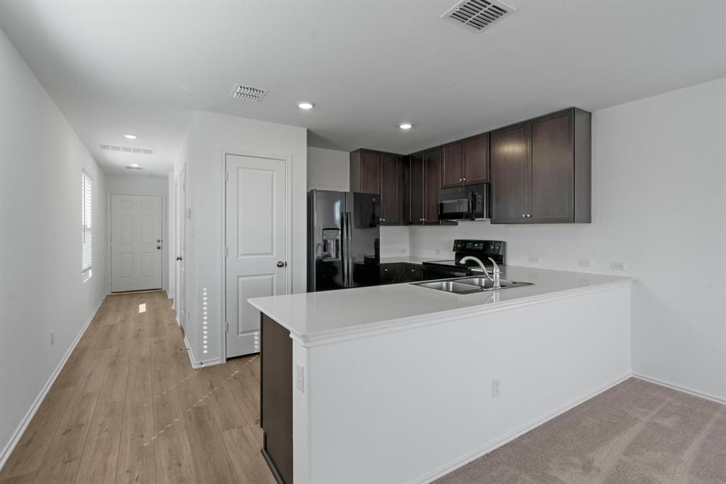 444 Marty Allen Loop Jarrell, TX 76537 - Photo 4 of 23 a kitchen with stainless steel appliances a refrigerator sink and cabinets