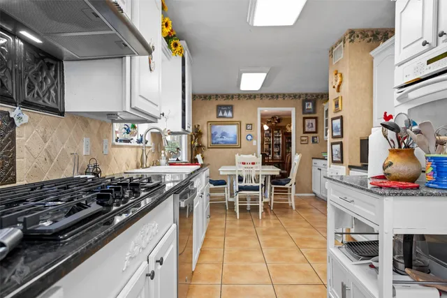 a kitchen with stainless steel appliances granite countertop a stove and cabinets