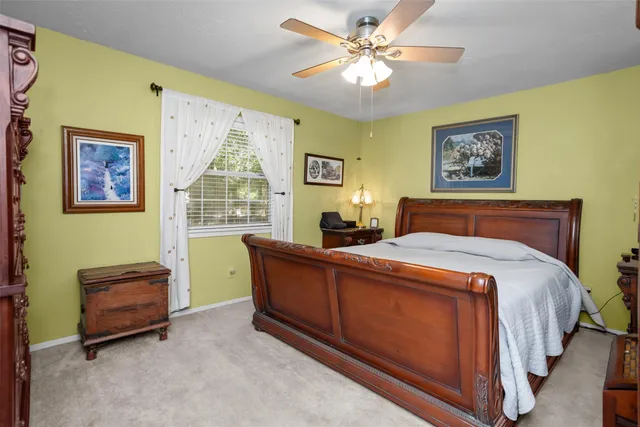 a bedroom with a bed a chair and a chandelier