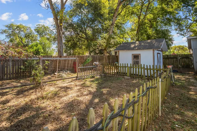 a backyard of a house with plants and large trees