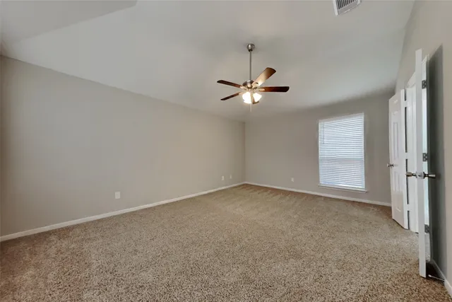 a view of an empty room with a chandelier fan