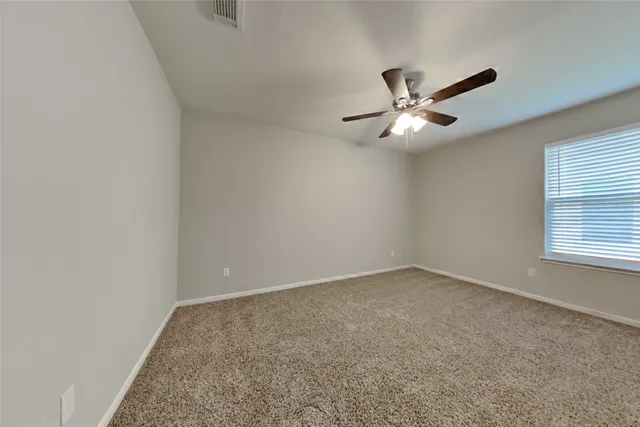 an empty room with a window and a ceiling fan