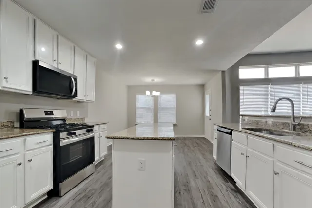a kitchen with a sink stove cabinets and refrigerator