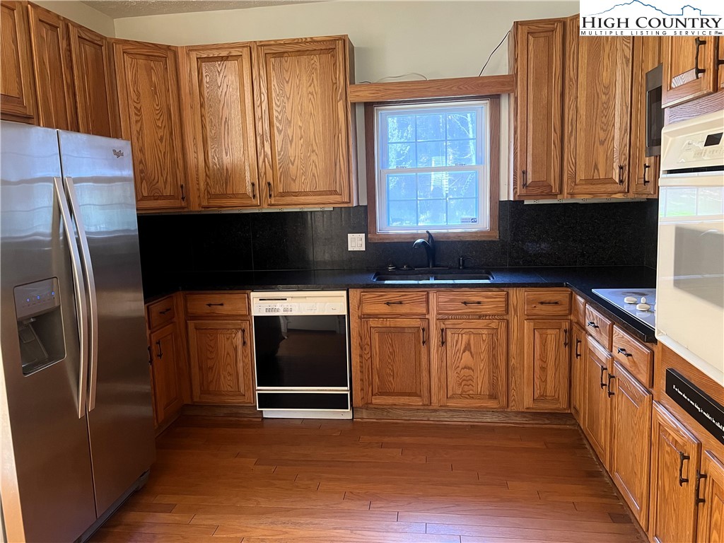 1371 West Buffalo Road West Jefferson, NC 28694 - Photo 13 of 31 a kitchen with stainless steel appliances granite countertop a refrigerator a stove a sink and dishwasher with wooden cabinets