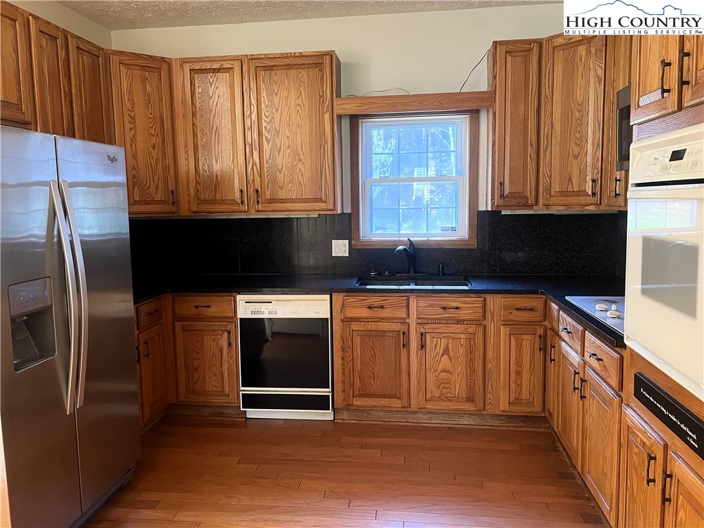 1371 West Buffalo Road West Jefferson, NC 28694 - Photo 14 of 31 a kitchen with granite countertop a refrigerator and a sink