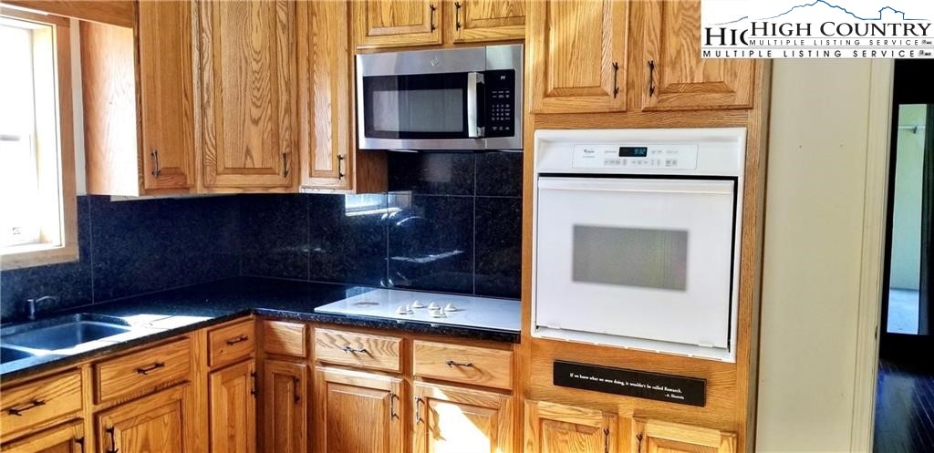 1371 West Buffalo Road West Jefferson, NC 28694 - Photo 3 of 31 a kitchen with granite countertop white cabinets and stainless steel appliances