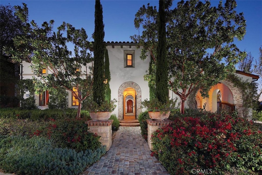 a front view of a house with a yard and garden