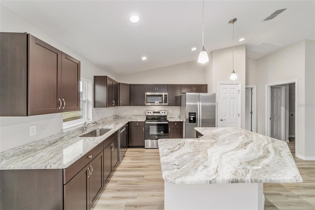 7866 North Manville Road Citrus Springs, FL 34434 - Photo 5 of 19 a large kitchen with kitchen island a sink stainless steel appliances and cabinets