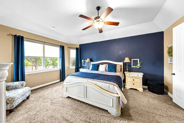 a spacious bedroom with a bed and ceiling fan