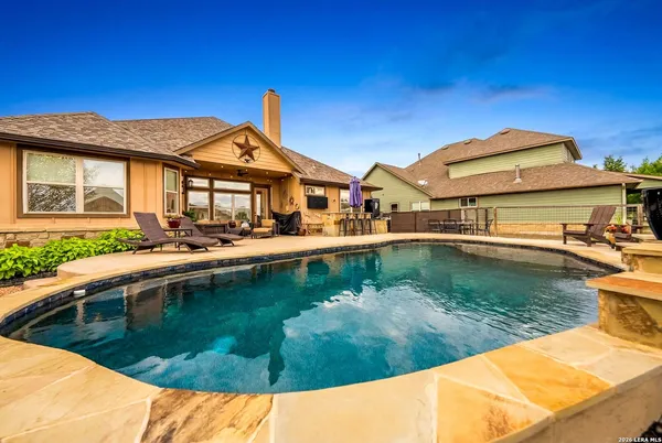 a view of a house with pool and chairs