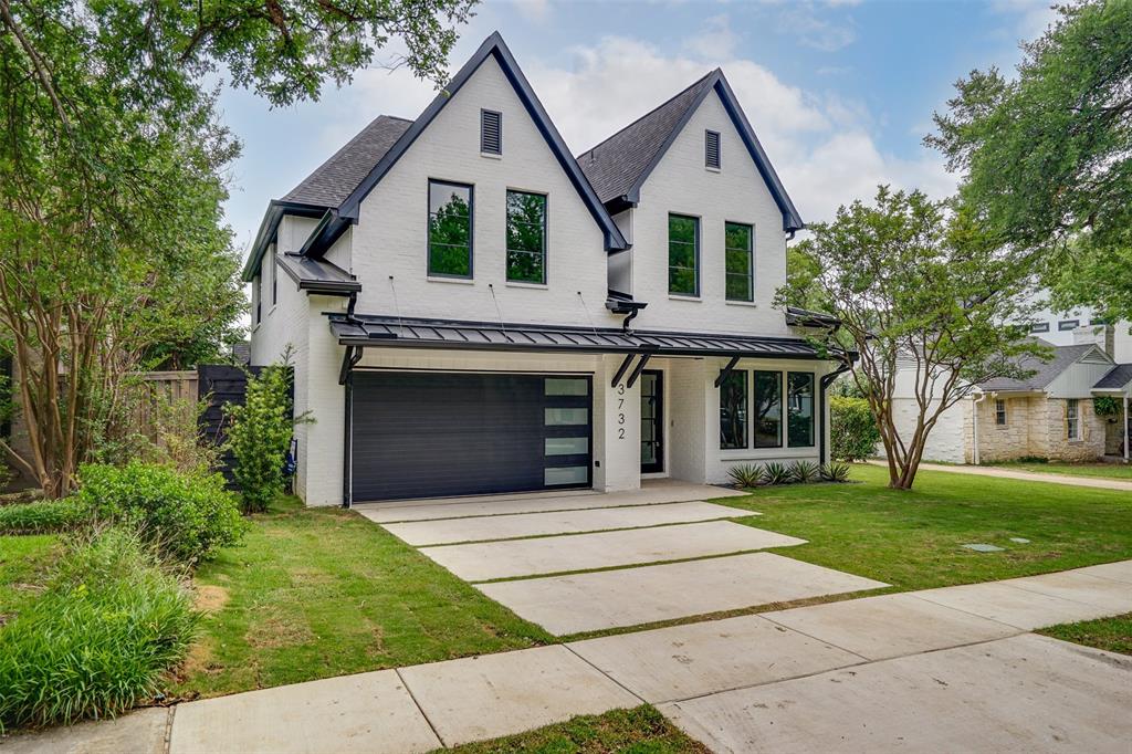 Modern inspired farmhouse featuring a standing seam roof, a metal roof, and a garage