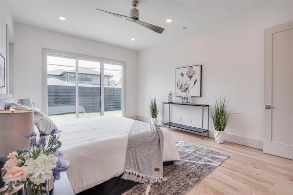 a bedroom with a bed painting on wall and a large window