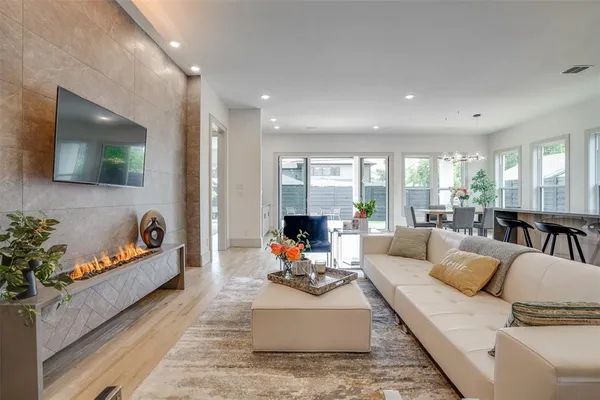 a large white kitchen with lots of counter space dining table and stainless steel appliances