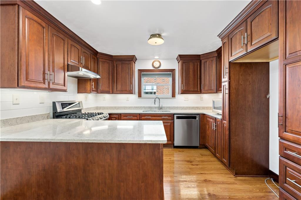 220 McClelland Road Canonsburg, PA 15317 - Photo 8 of 38 a kitchen with stainless steel appliances granite countertop a refrigerator a sink dishwasher and wooden cabinets with wooden floor