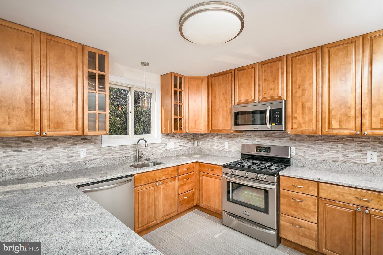 9120 Bengal Road Randallstown, MD 21133 - Photo 1 of 30 a kitchen with stainless steel appliances granite countertop a stove a sink and a microwave