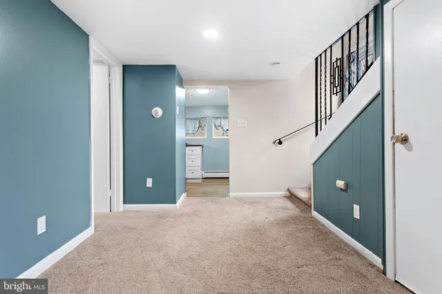 a view of an empty room with stairs and wooden floor
