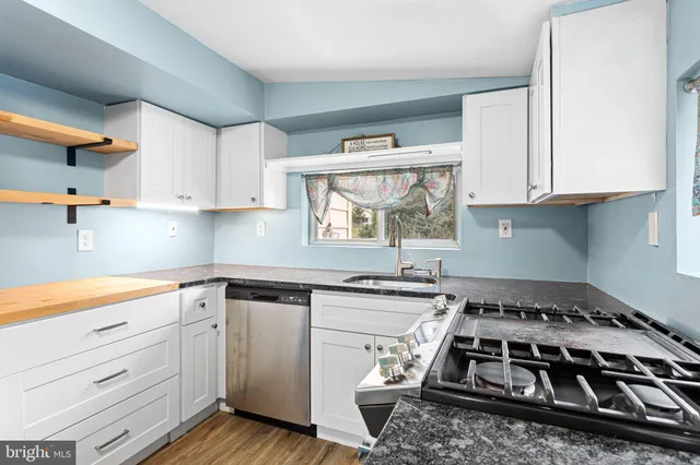 a kitchen with a stove and white cabinets
