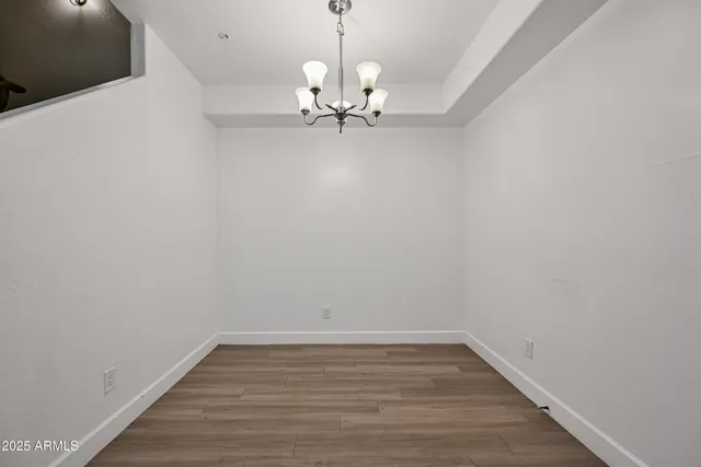 a view of a room with wooden floor and ceiling fan