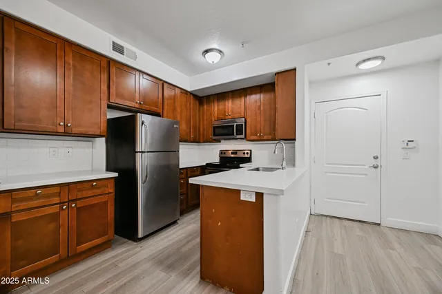 a kitchen with cabinets a refrigerator and a stove top oven