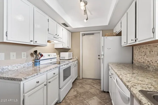 a kitchen with granite countertop a sink stove and refrigerator